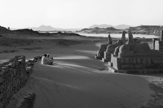 A black and white photo of Lake Nesser and the temple of el Seboua.