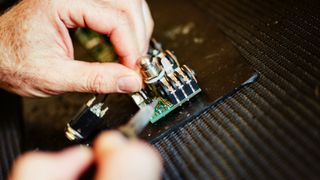 A man building a DIY guitar pedal kit