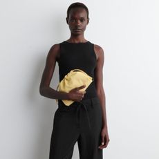 woman holding yellow clutch