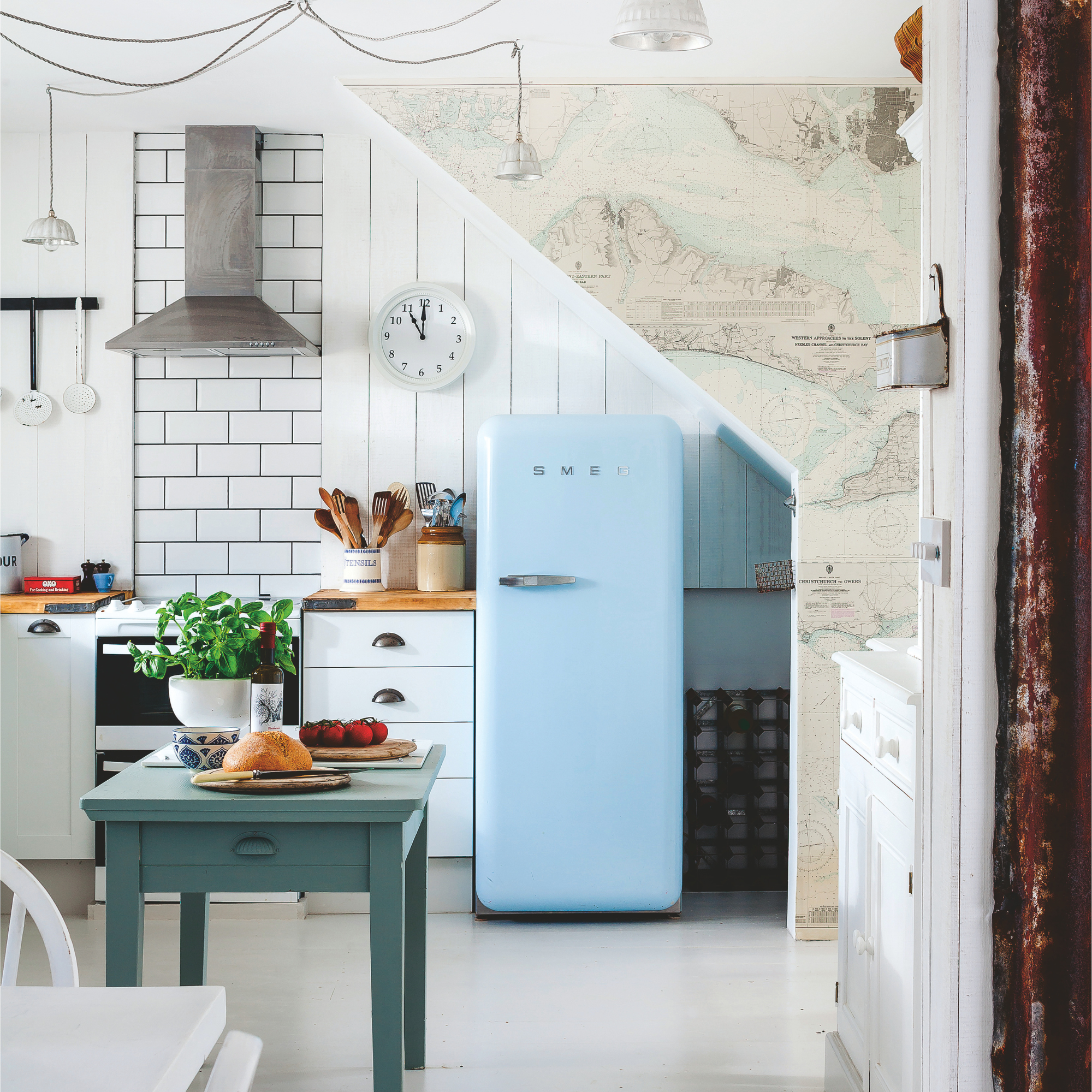 A view into the kitchen from the dining area looking towards the pale blue Smeg fridge.