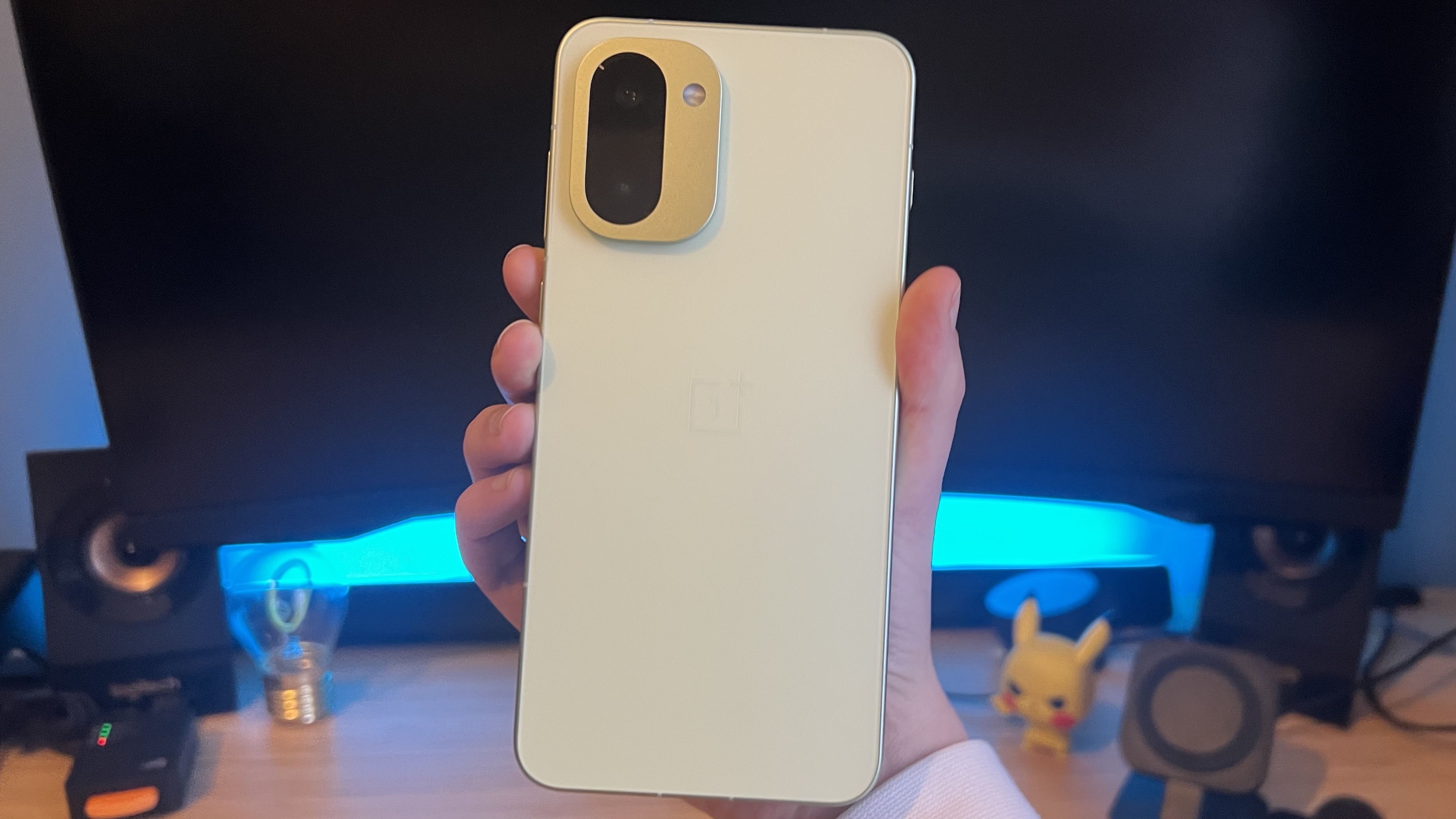 Hand holding OnePlus 15R phone with its back to the camera