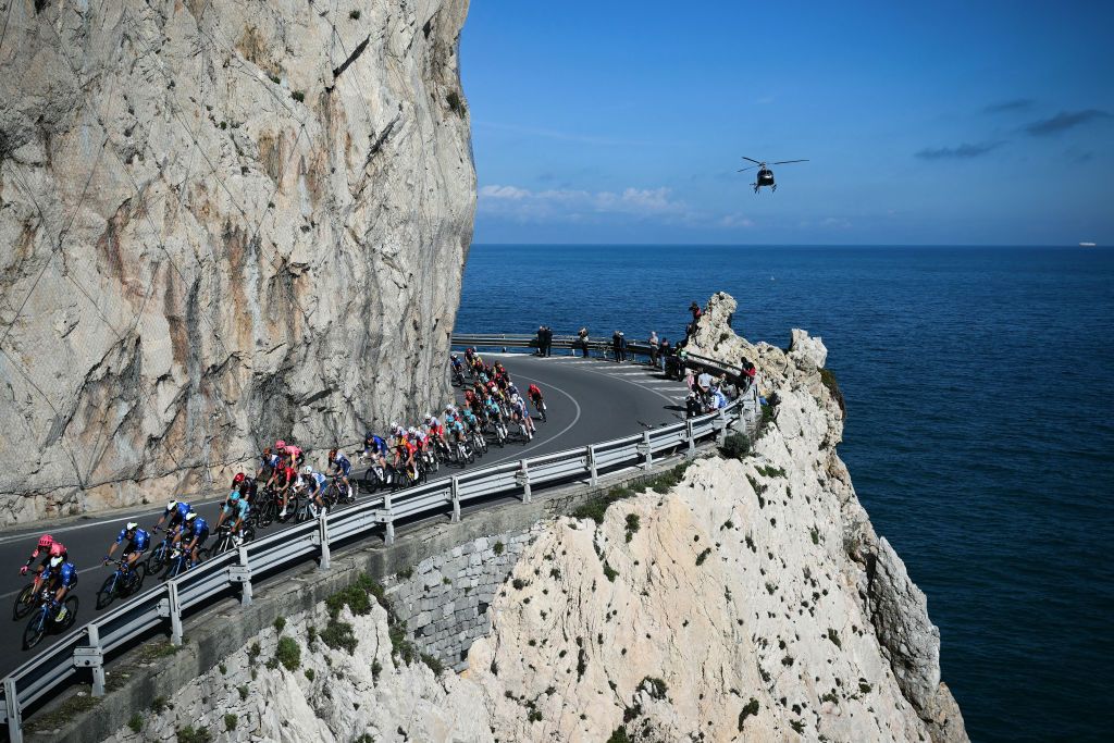 The pack rides along Capo Noli during the 115th Milan-SanRemo one-day classic cycling race, between Pavia and SanRemo, on March 16, 2024. (Photo by Marco BERTORELLO / AFP)