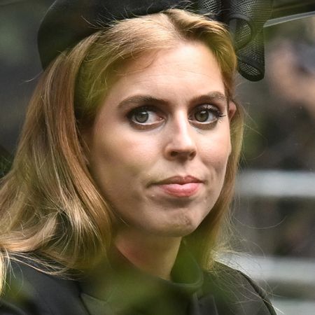 Princess Beatrice wears a black hat with a black coat