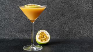 Passionfruit martini in glass with half a passionfruit