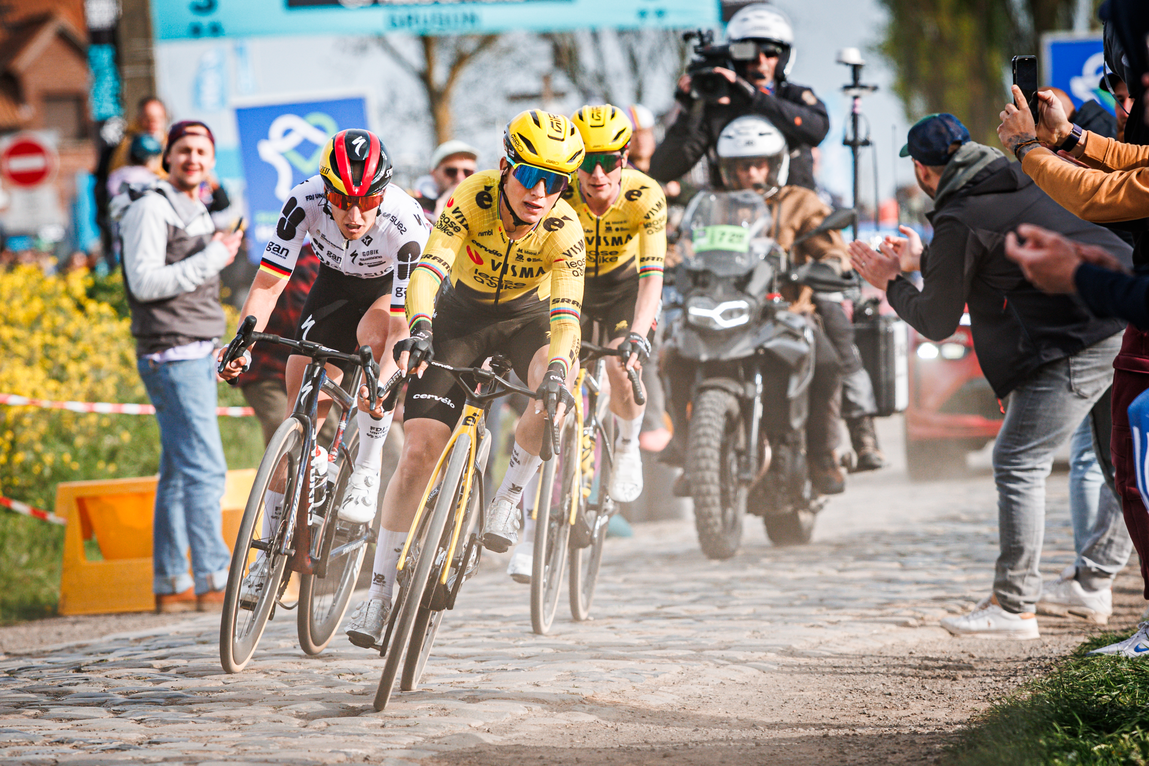 A head-on shot of Pauline Ferrand-Prévot leading teammate Marianne Vos and rival Franziska Koch round a corner on a late cobbled sector in Paris-Roubaix 2026