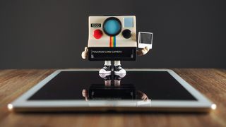 A Polaroid Funki Pop! standing on top of an iPad Air 2 on a wooden surface