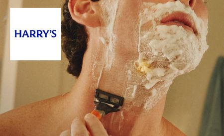 Man shaving using harry's shaving cream and razor