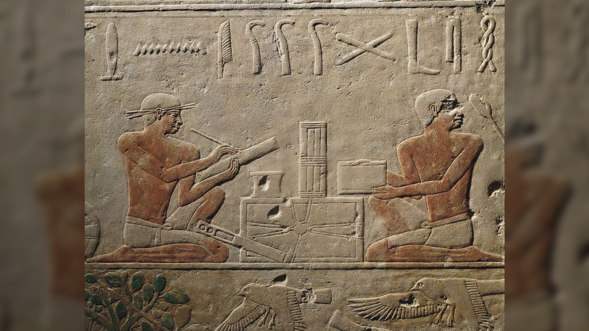 This is a relief from the mastaba of Akhethotep in Saqqara, Old Kingdom from around the 5th dynasty, ca. 2494-2345 BC.  Here we see 2 scribes facing each other.  One writes on a tablet while the other holds up parchment.  Above are several hieroglyphs, and below are 2 images of flying birds.
