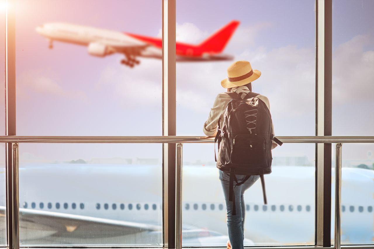 Travel photo of woman watching airplane takeoff