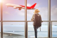 Travel photo of woman watching airplane takeoff