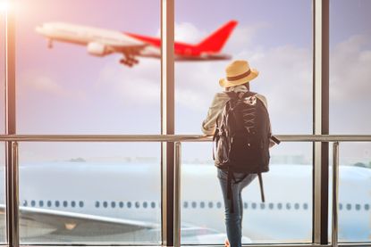 Man looking outside at flying airplane