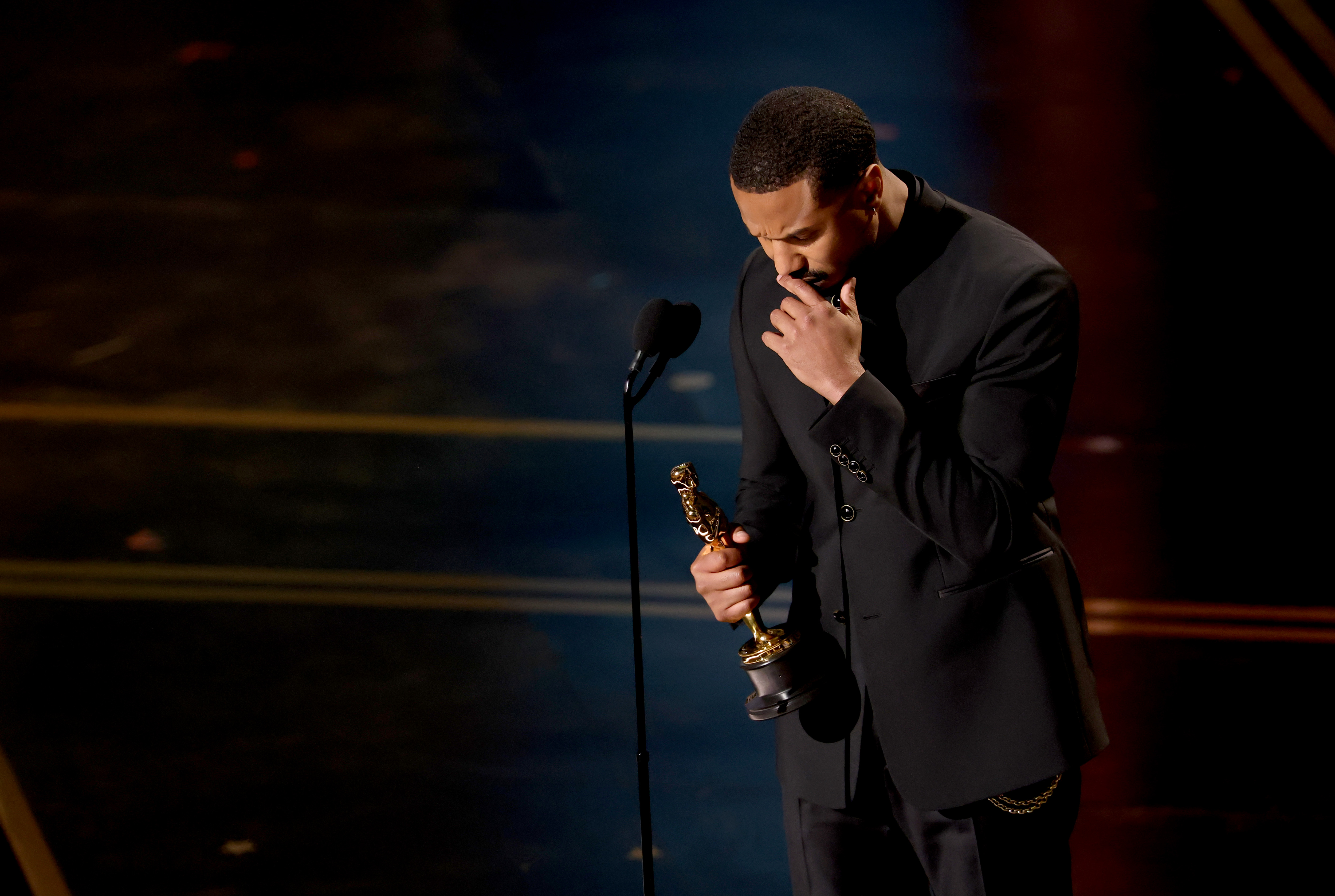 Michael B. Jordan looks emotional and rests his head in his hand as he accepts the Actor in a Leading Role award for sinners onstage during the 98th Oscars at Dolby Theatre on March 15, 2026 in Hollywood, California