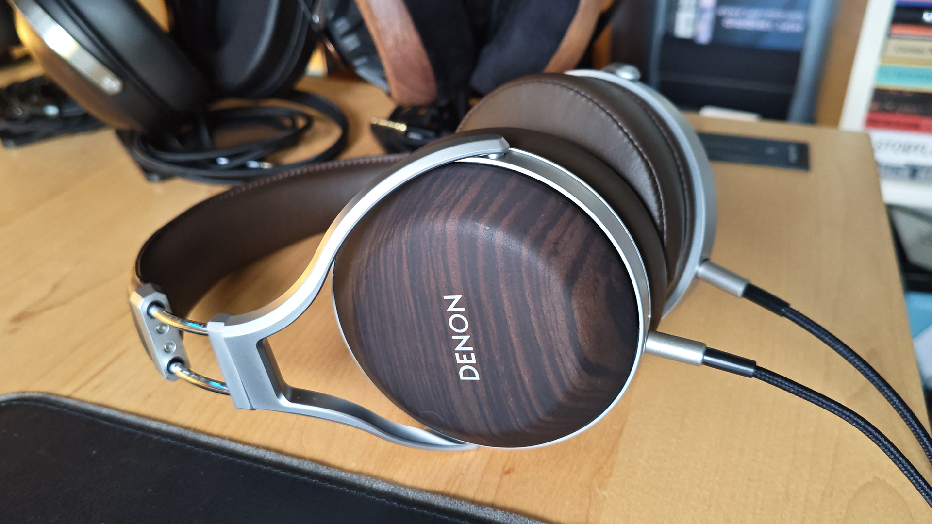 The Denon AH-D5200 and other headphones, photographed on a home desktop. 