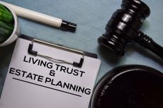 Living trust and Estate Planning text on Document form and Gavel isolated on office desk.