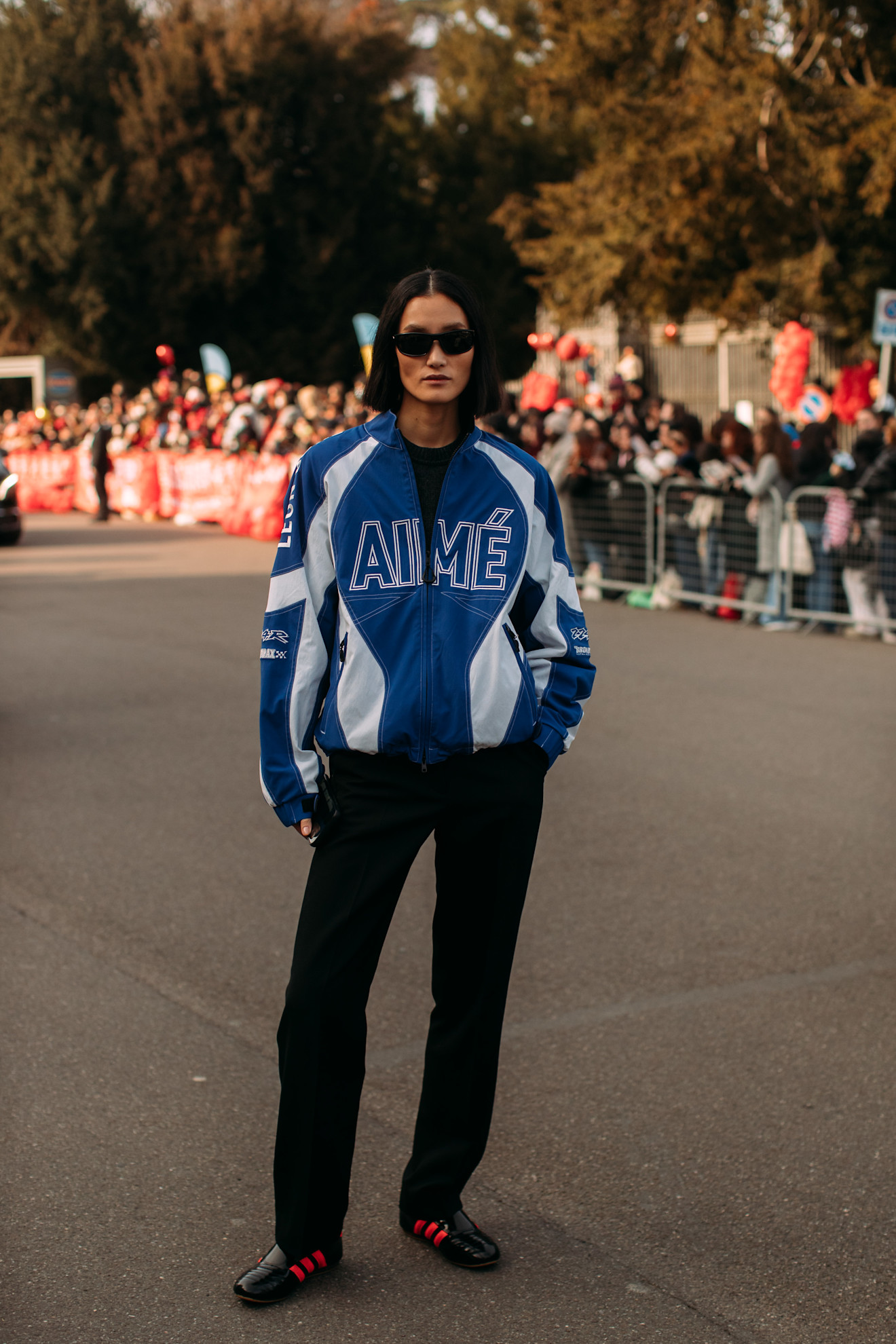 woman wearing a blue jacket, blakck jeans, and black sneakers