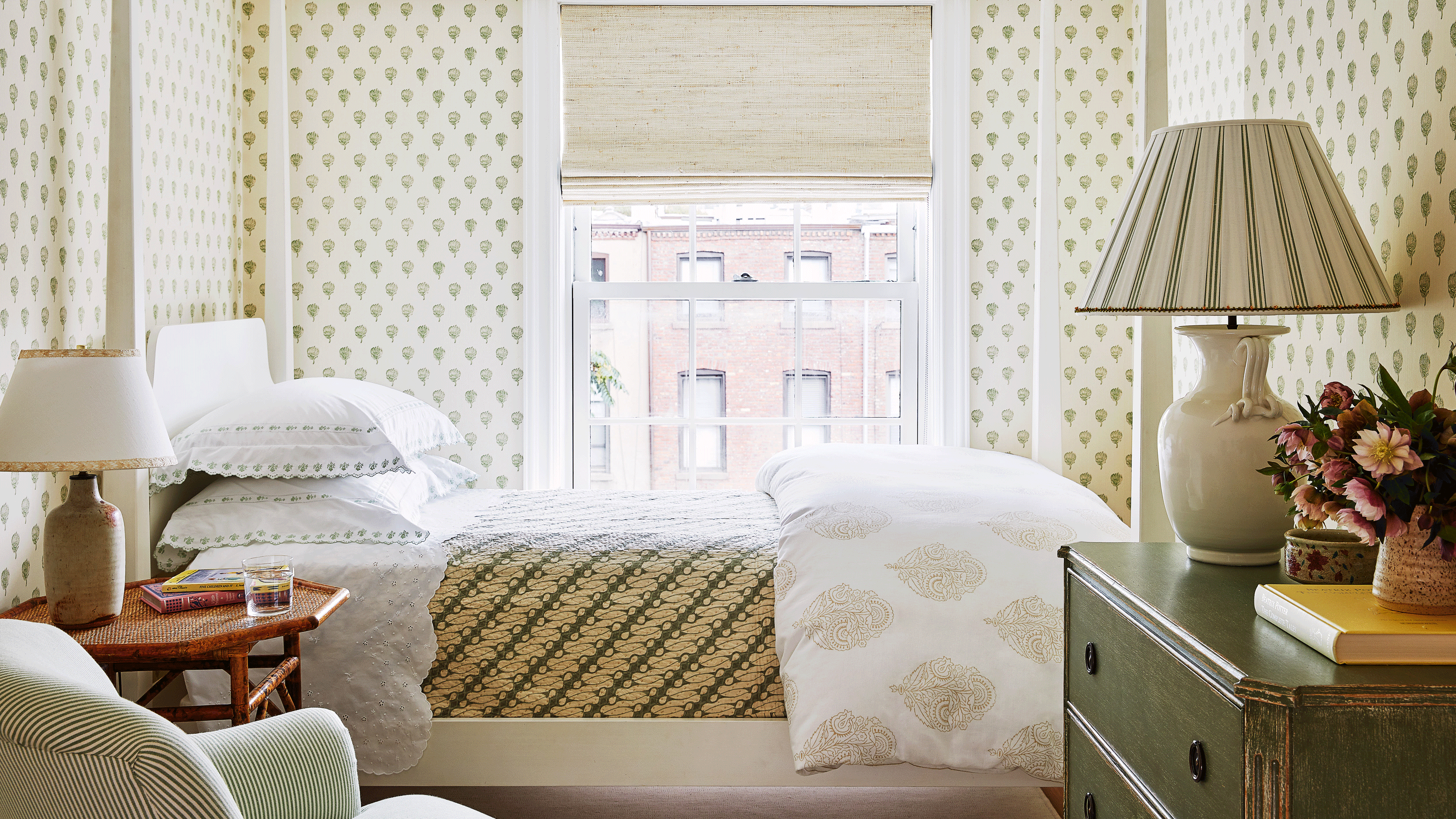 small bedroom with patterned wallpaper and patterned bedding and furnishing