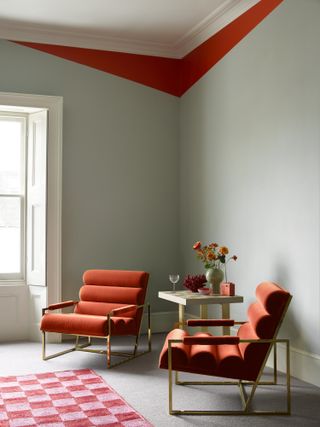 Corner of a room with blue walls and red accent corner, red armchairs