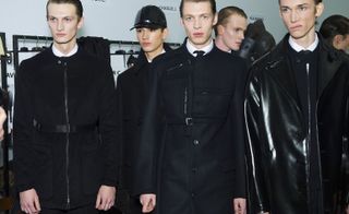 Group of male models stood looking at the camera with black jackets on