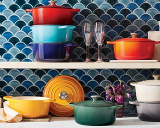 Image of various Le Creuset pots on kitchen shelves