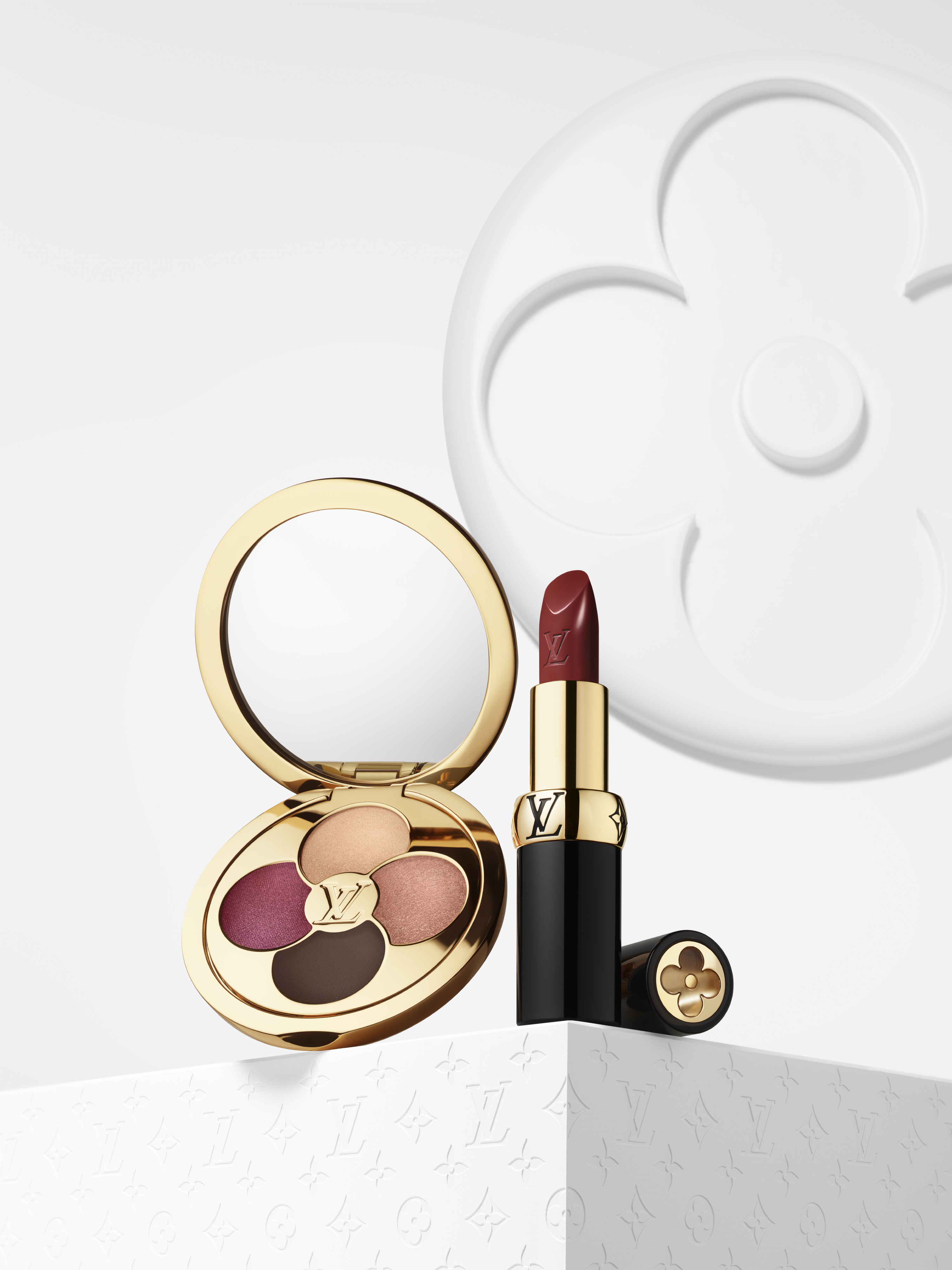 an eyeshadow palette with four shades and a tube of lipstick