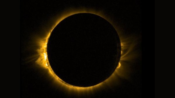 photo of a solar eclipse, showing the moon blotting out the sun, except for a thin yellow-orange ring around the outside