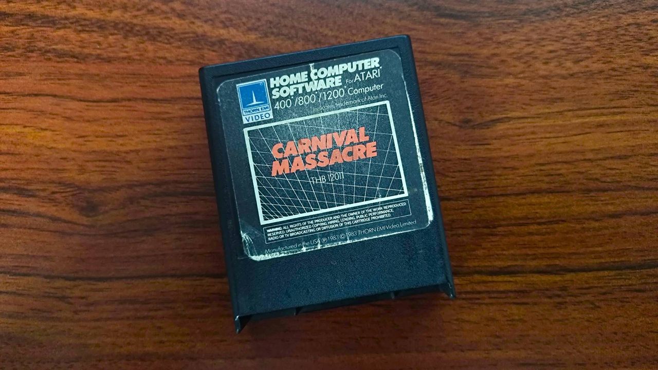 Carnival Massacre Atari cartridge on woodgrain desk.
