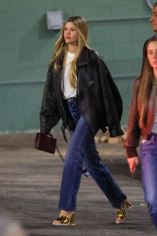 Sofia Richie Grainge leaves a Paris Hilton concert wearing an oversize leather jacket with high waist jeans and tall metallic sandals