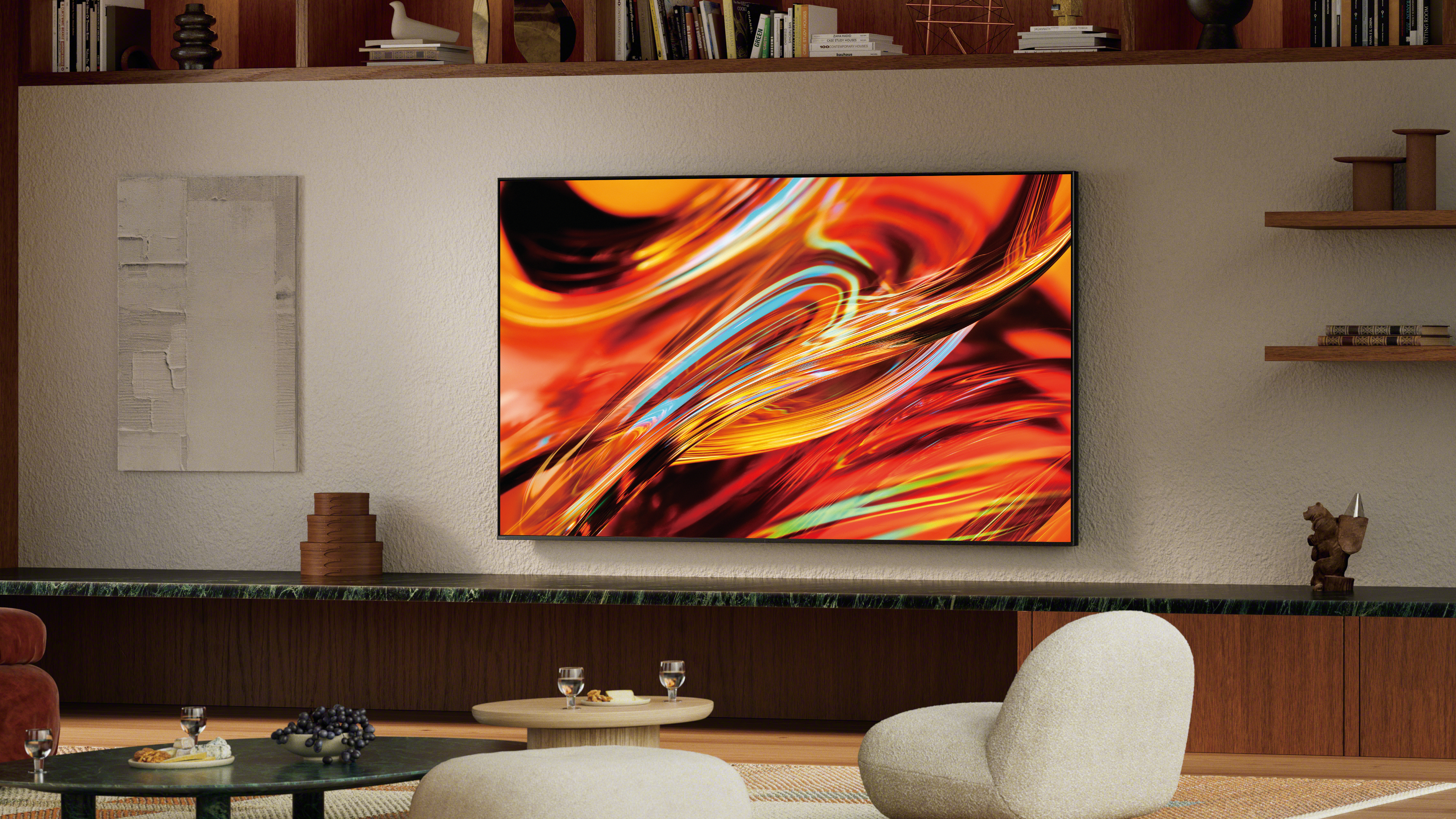 A wall-mounted Sony Bravia 7 II True RGB Mini-LED TV displaying a colorful, abstract image in a modern living room