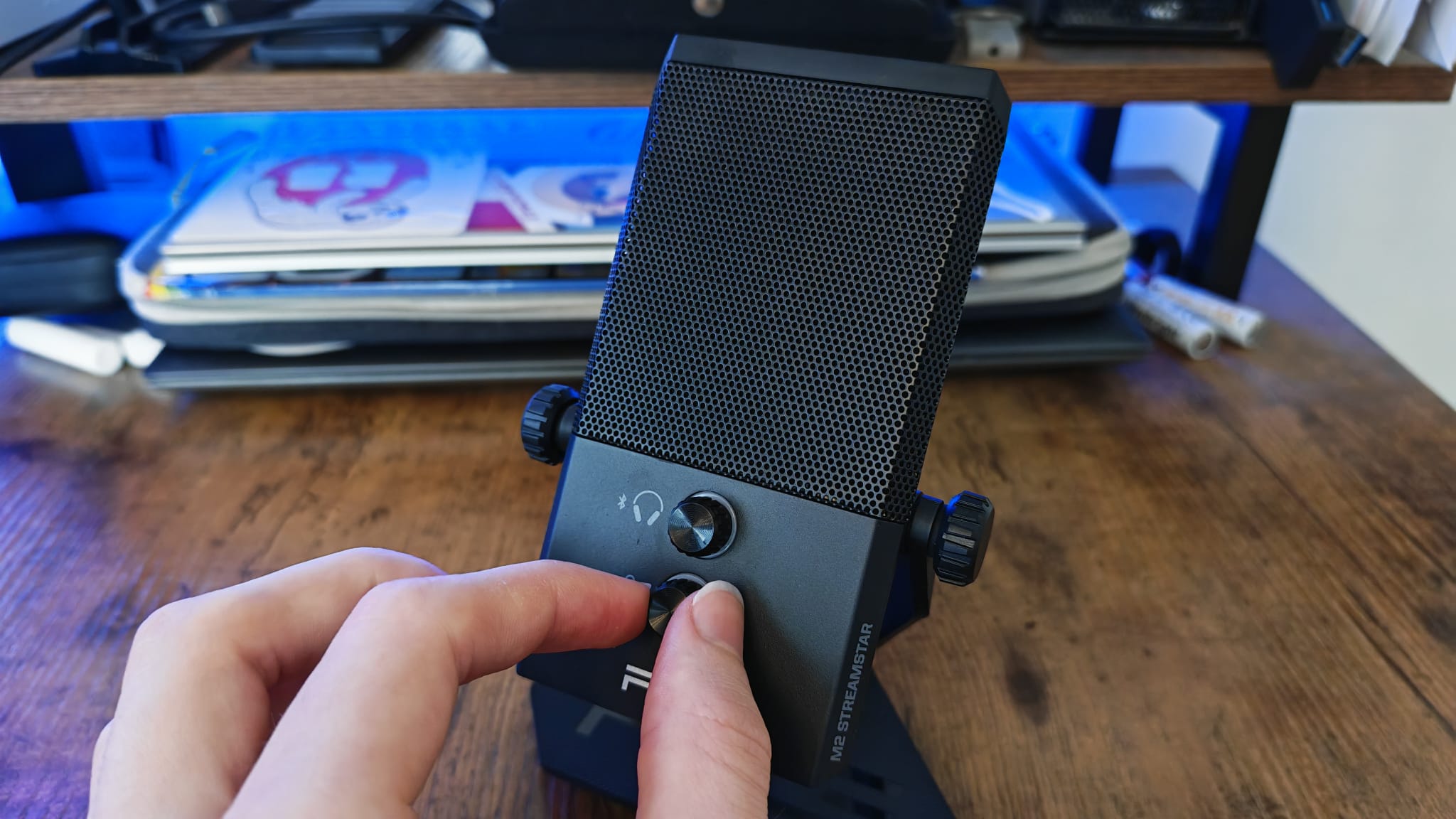 A reviewer adjusting the gain level on the RIG M2 Pro HD Streamstar