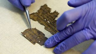 A conservator of the Israel Antiquities Authority (IAA) shows fragments of the Dead Sea Scrolls at their laboratory in Jerusalem on June 2, 2020.