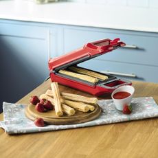 red churro maker with churro and strawberries