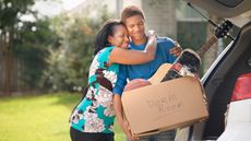 Mother hugging teenage son who is packed for college