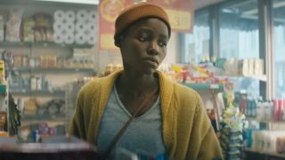 Lupita Nyong'o looking at a clerk with a straight face in A Quiet Place: Day One.