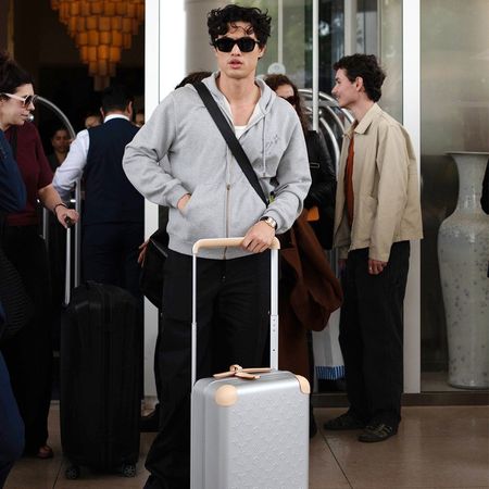 Charles Melton with a Louis Vuitton suitcase