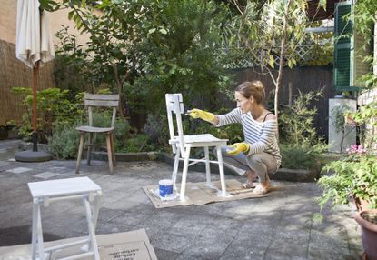 diy stores: woman painting chairs 
