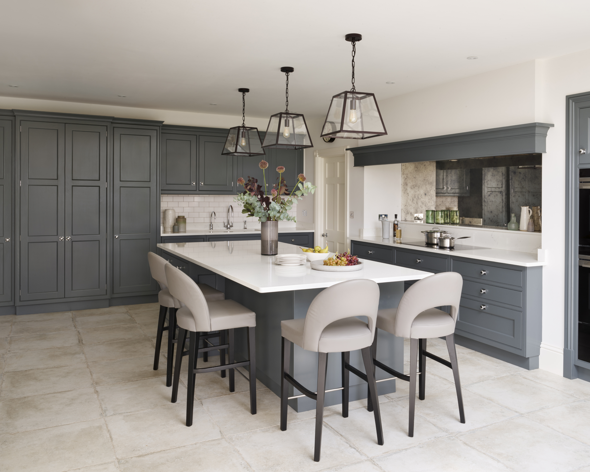 Kitchen lighting ideas in a modern grey kitchen with industrial pendant lights over a white island.
