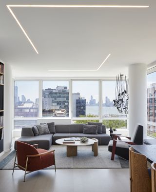 A gray sofa with a red and gray accent chair in an apartment in the US