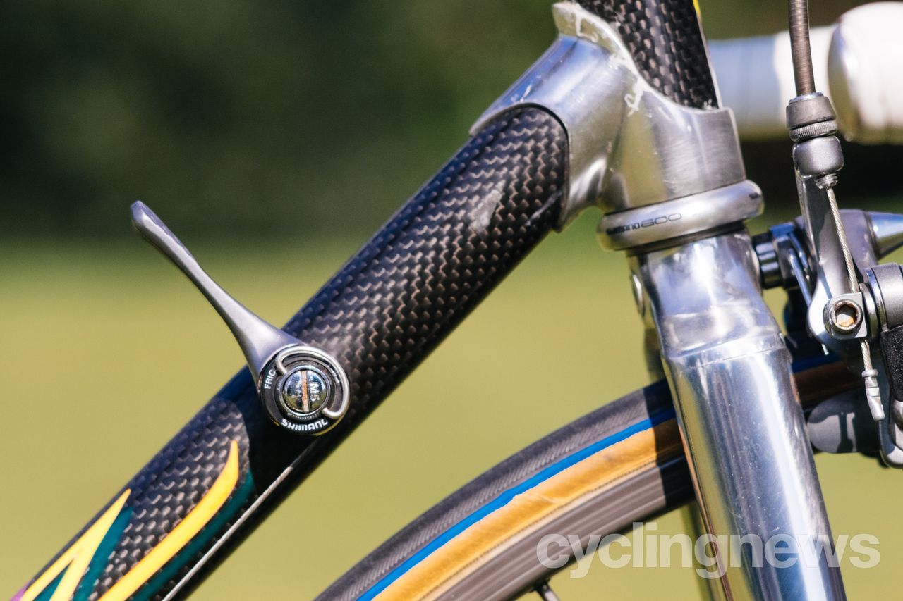 close up of downtube shifters and front tyre on a black bike