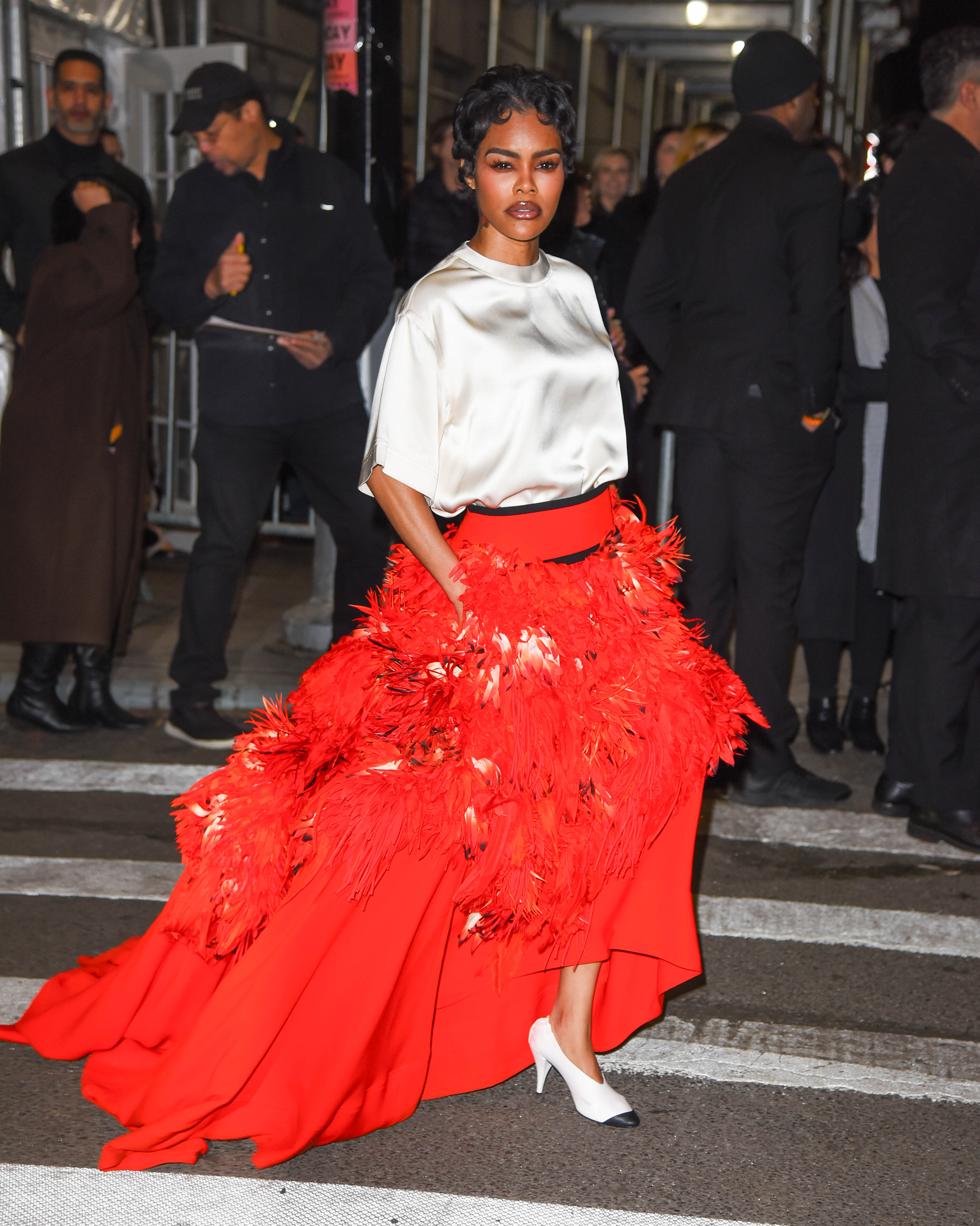 Teyana Taylor wears a white and red Chanel two-piece with Chanel two-tone cone heel shoes.
