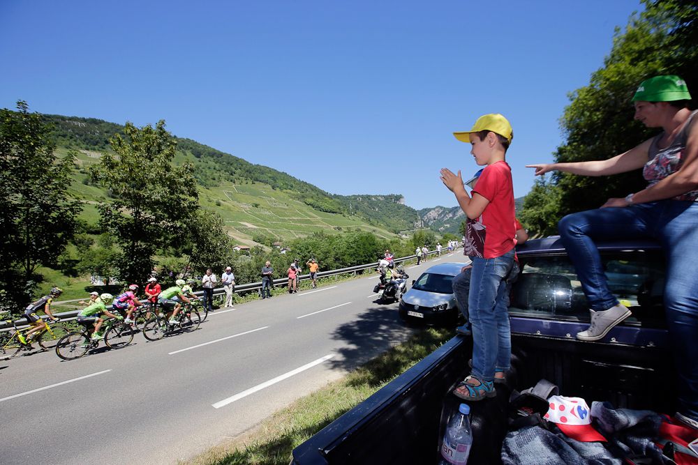 A fan finds a perch as the 2016 Tour de France peloton cruises by.