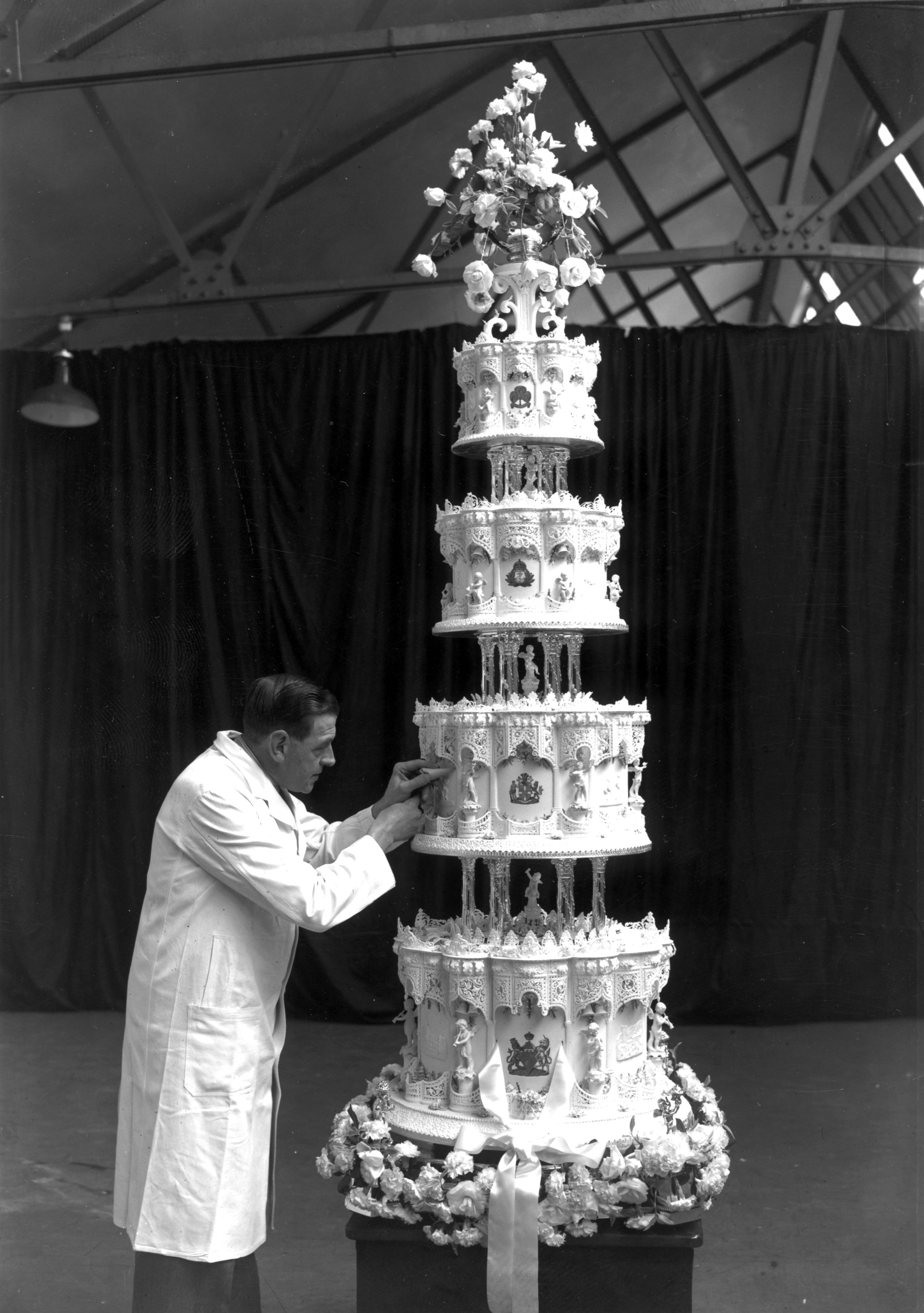 A man putting touches on Queen Elizabeth's wedding cake