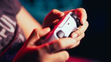 Playing PS5 – close-up of hands playing with a PS5 DualSense controller