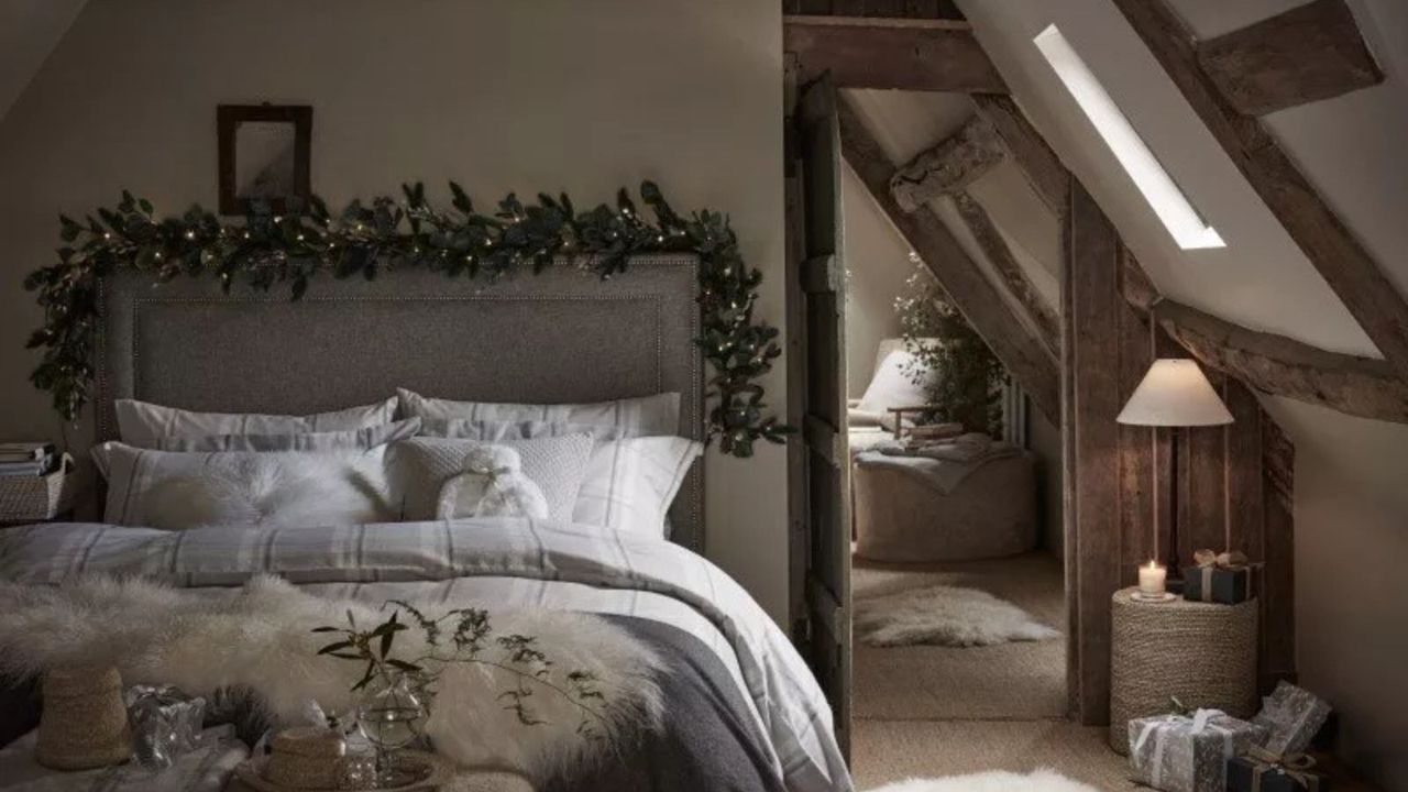 A garland around a bed frame with bedding from The White Company.