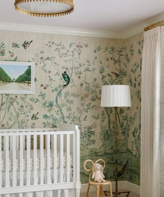 vintage lighting in a wallpapered baby nursery with a white crib