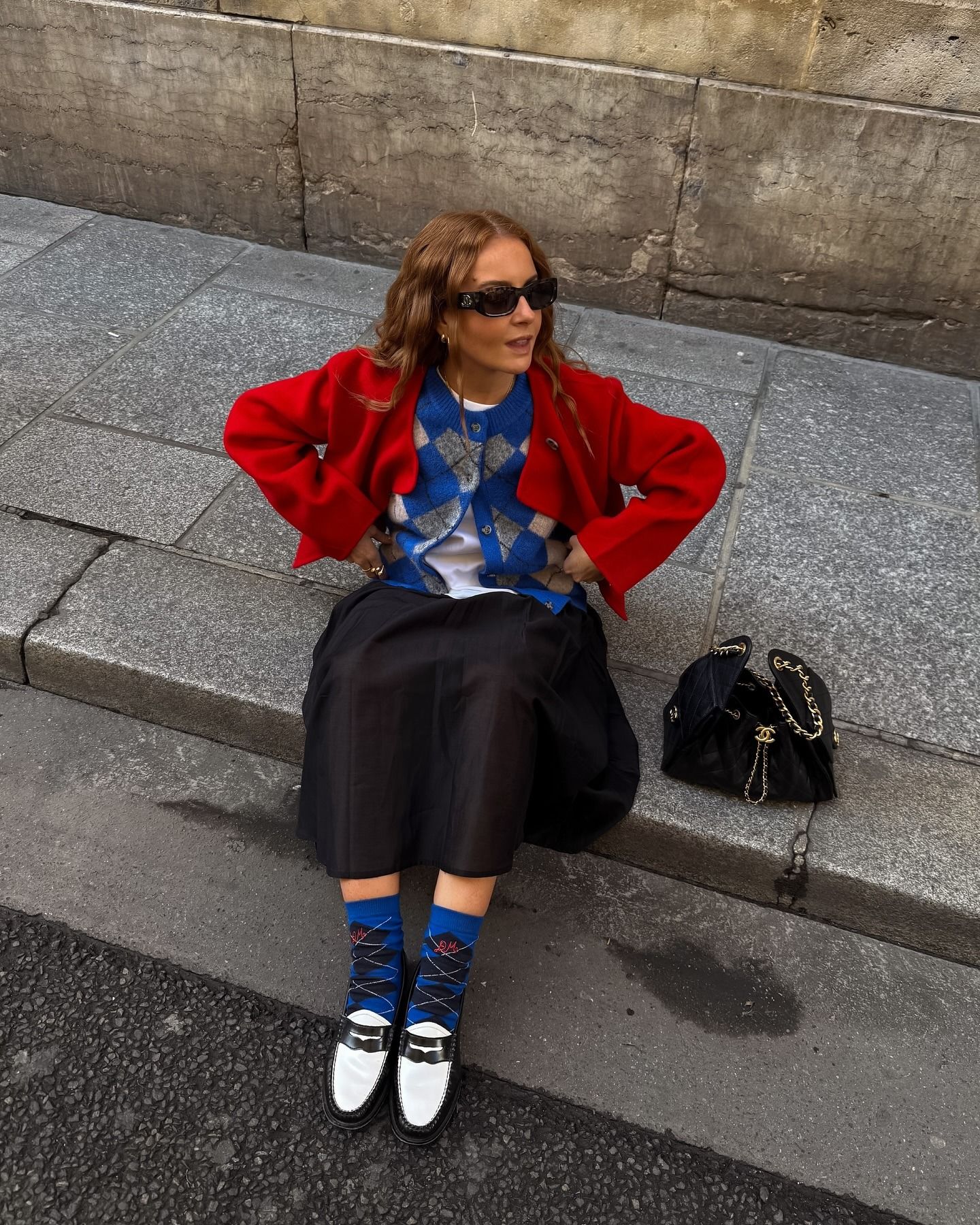 Rebecca Ferrazwyatt wears a black skirt with an argyle cardigan.