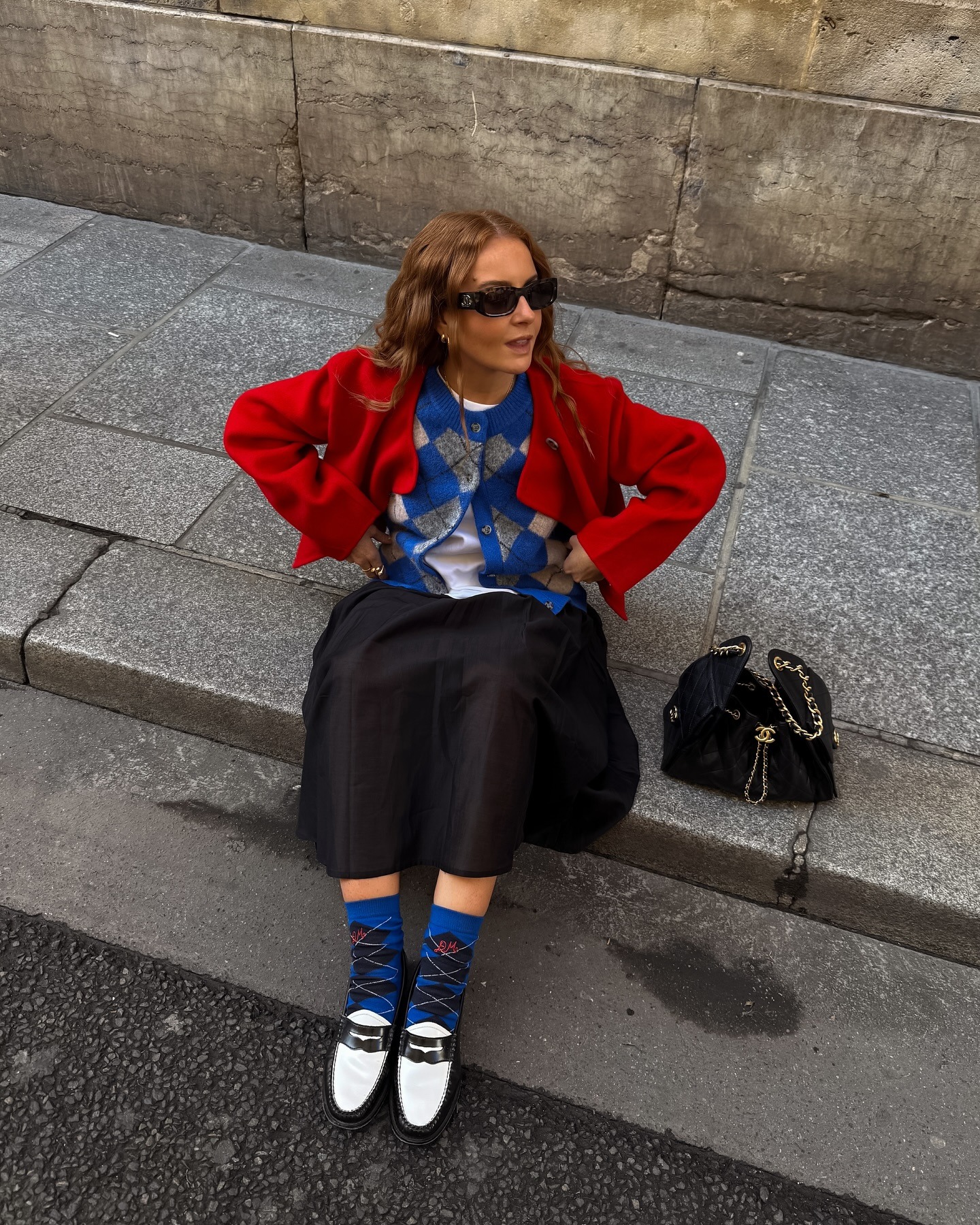 Rebecca Ferrazwyatt wears a black skirt with an argyle cardigan.