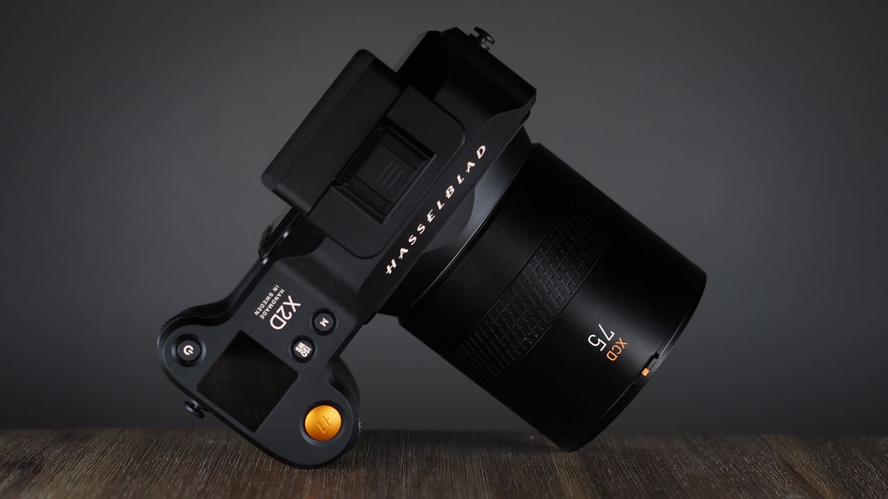 Hasselblad XCD 75P lens on a Hasselblad X2D camera, on a wooden surface against a dark background