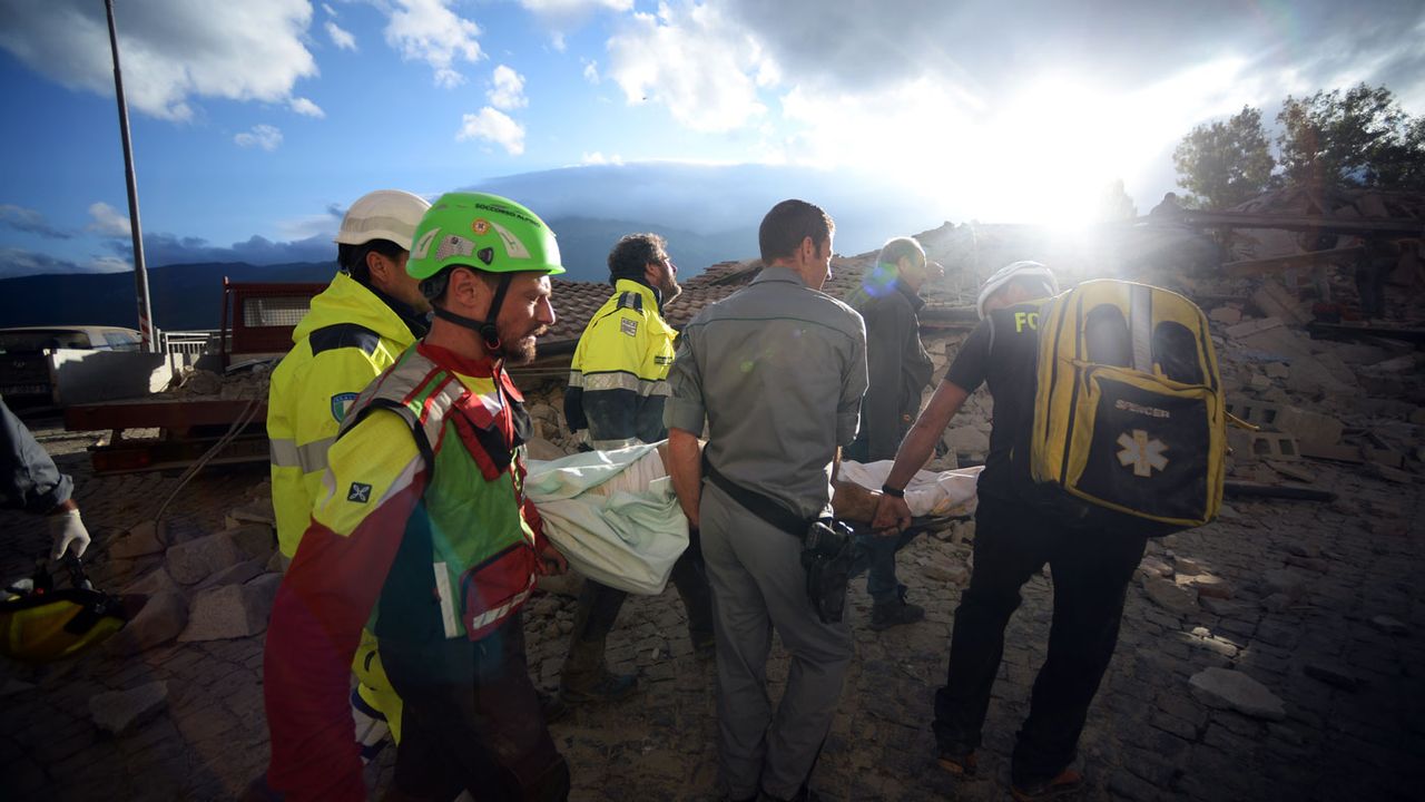 Rescuers carry an man injured by the 6.2-magnitude earthquake which hit central Italy on Wednesday