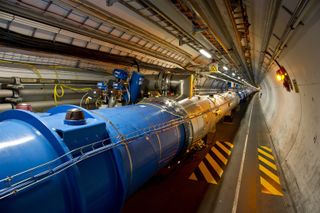 This photo shows the tunnel of the Large Hadron Collider, where beams of particles pass through the central pipes before colliding with each other.
