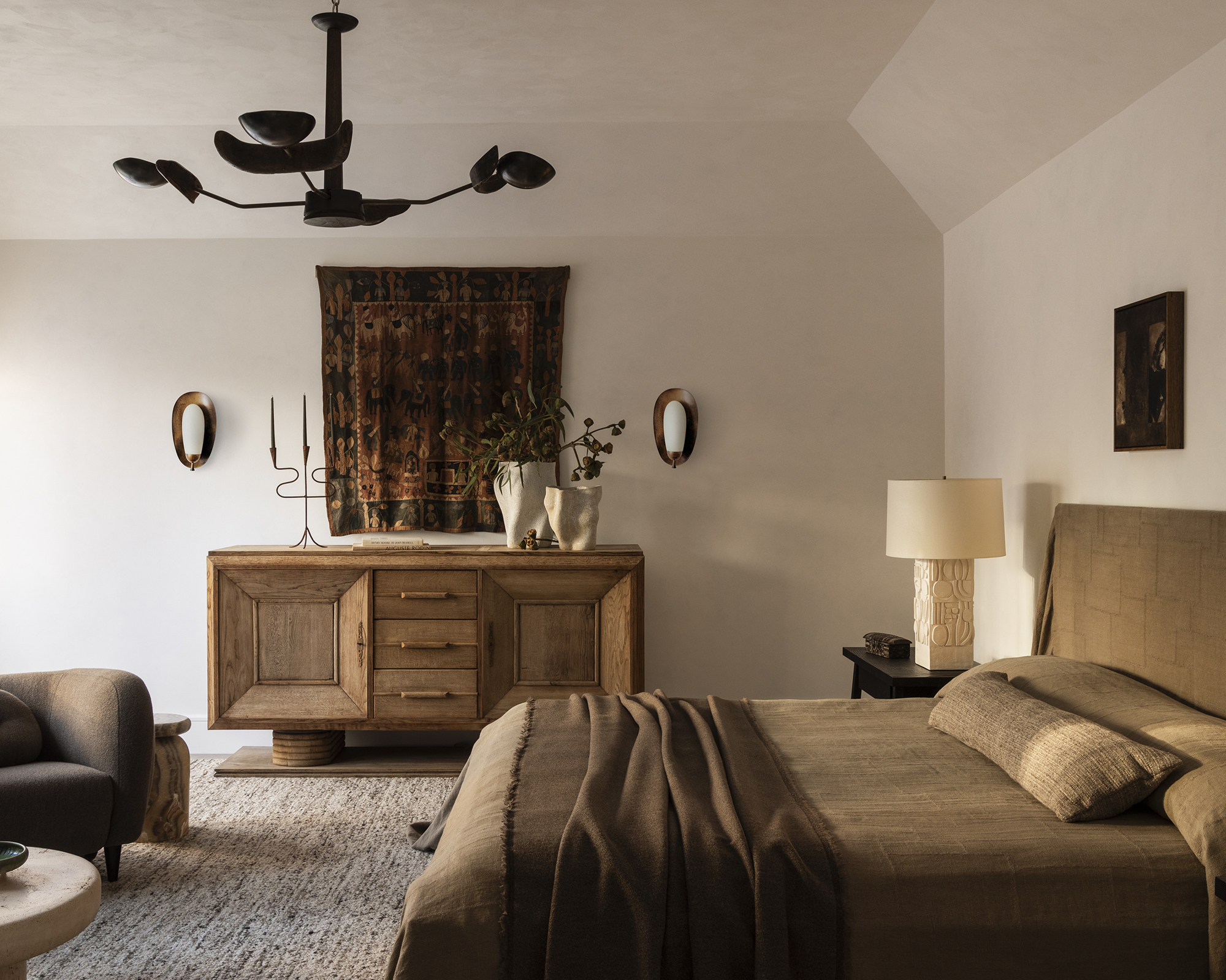 neutral bedroom with pale walls and brown bed linen and wood cabinet